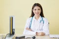 Asian woman doctor wears medical coat with stethoscope,  blood pressure monitor and shows its in office room at hospital in health Royalty Free Stock Photo