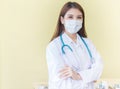 Asian woman doctor in white lab coat stand with arms crossed. Royalty Free Stock Photo