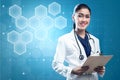 Asian woman doctor in white lab coat and stethoscope holding clipboard Royalty Free Stock Photo