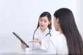 Asian woman doctor who wears medical uniform gives information and suggestion to female patient in healthcare concept Royalty Free Stock Photo