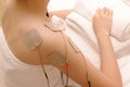 Asian woman is doing massage of electrical -stimulation ( TENs ) Royalty Free Stock Photo