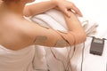 Asian woman is doing massage of electrical -stimulation ( TENs ) Royalty Free Stock Photo