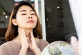 Asian woman doing self lymph node, checking thyroid gland on her neck