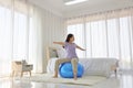 Asian woman doing yoga exercise with fitness ball in her bedroom as a result of social distancing and quarantine Royalty Free Stock Photo