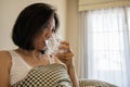 Asian woman drink water after wake up in the morning sitting on a bed Royalty Free Stock Photo