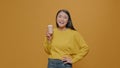 Asian woman drinking coffee from cup in front of camera