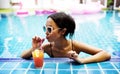 Asian woman drinking juice by the poolside Royalty Free Stock Photo