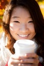 Asian woman drinking a warm drink