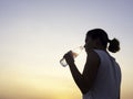 Asian woman drinking water after exercise. Royalty Free Stock Photo