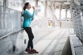 Asian woman drinking water and resting after jogging in the city in the morning Royalty Free Stock Photo