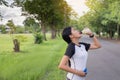 Asian woman drinking water after running exercise at the garden in sunset Royalty Free Stock Photo