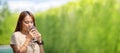 Asian Woman drinks water from tall glass of water at outdoor tree bokeh green for banner background Royalty Free Stock Photo