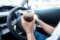 Asian woman driver holding cup for drink water while driving a car. Plastic hot water bottle cause fire Royalty Free Stock Photo