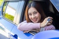 Asian woman driver smiling and showing new car keys. Royalty Free Stock Photo