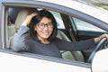 Asian woman driving car lookiing to camera with smiling face hap