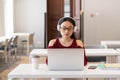 Asian woman in earphones watching webinar video course on laptop. E-learning and remote education Royalty Free Stock Photo