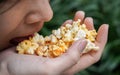 Asian woman easting popcorn full hand closed up