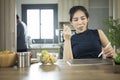 Woman eating healthy salad for breakfast and using digital tablet in home kitchen. Royalty Free Stock Photo