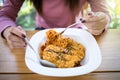 Asian woman eating instant noodles with fork on blurred background of restaurant Royalty Free Stock Photo