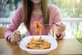 Asian woman eating instant noodles with fork on blurred background of restaurant Royalty Free Stock Photo