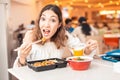 Woman eating Japanese bento lunchbox and miso soup in sushi bar