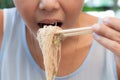 Asian woman eating noodles