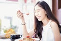 Asian woman eating strawberry pancakes in a cafe. A woman eating strawberry and honey by stainless spoon