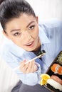 Asian woman eating sushi. Shallow depth of field, focu