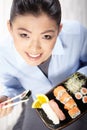 Asian woman eating sushi. Shallow depth of field, focu