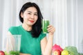 Asian woman embracing health with a glass of green fruit and vegetable juice rich in natural fiber Royalty Free Stock Photo