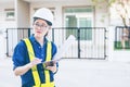 Asian woman engineer or architecture hold clipboard and looking at construction site or work place and checking audit checklist. Royalty Free Stock Photo