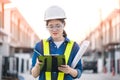 Asian woman engineer or architecture hold clipboard standing face to camera at construction site and checking audit checklist. Royalty Free Stock Photo