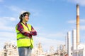 Asian woman engineer arm crossed and smile with confident looking forward to future with oil refinery plant factory in background Royalty Free Stock Photo