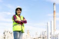 Asian woman engineer arm crossed and smile with confident looking forward to future with oil refinery plant factory in background Royalty Free Stock Photo