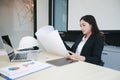 Asian women engineering holding blueprints and have hard hat on table  for working at office Royalty Free Stock Photo