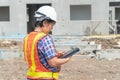 Asian women engineering holds a tablet for use in the inspection of construction sites for accuracy and in accordance with the pla