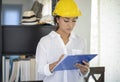 Asian women engineering inspecting and working and holding blueprints at home office Royalty Free Stock Photo