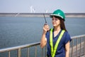 Asian woman engineers are using walkie-talkies outdoors on site power plant energy