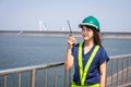 Asian woman engineers are using walkie-talkies outdoors on site power plant energy