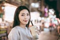 Asian woman enjoy bubble milk tea with street food in Night Market