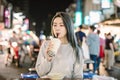 Asian woman enjoy bubble milk tea with street food in Night Market