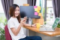 Asian woman enjoy herself while using internet on laptop and phone in office. Business and marketing and part time concept.