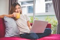 Asian woman enjoy herself while using  internet on laptop and phone in office. Business and marketing and part time concept. Royalty Free Stock Photo