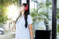 Asian woman with eyeglass listening to music with headphones and holding a cup of coffee with a laptop on the table Royalty Free Stock Photo