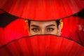 Asian woman eyes behind red chinese fan to celebrate Chinese new year Royalty Free Stock Photo