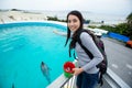 Asian Woman feeding dolphin in aquarium