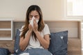 Asian woman feeling unwell and sneezing on the bed Royalty Free Stock Photo