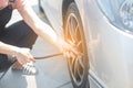 Asian woman filling air into a car tire to increase pressure car tire. Royalty Free Stock Photo