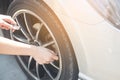 Asian woman filling air into a car tire to increase pressure car tire. Royalty Free Stock Photo