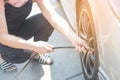 Asian woman filling air into a car tire to increase pressure car tire. Royalty Free Stock Photo